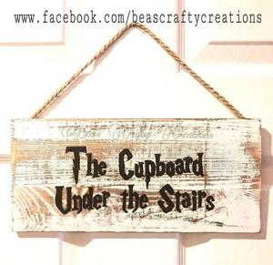 Wall plaque :  “The cupboard under the stairs”